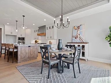 A dining room with a table and chairs and a chandelier.