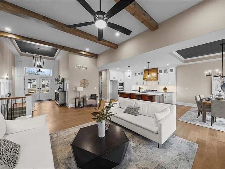 A living room with a couch , coffee table and ceiling fan.