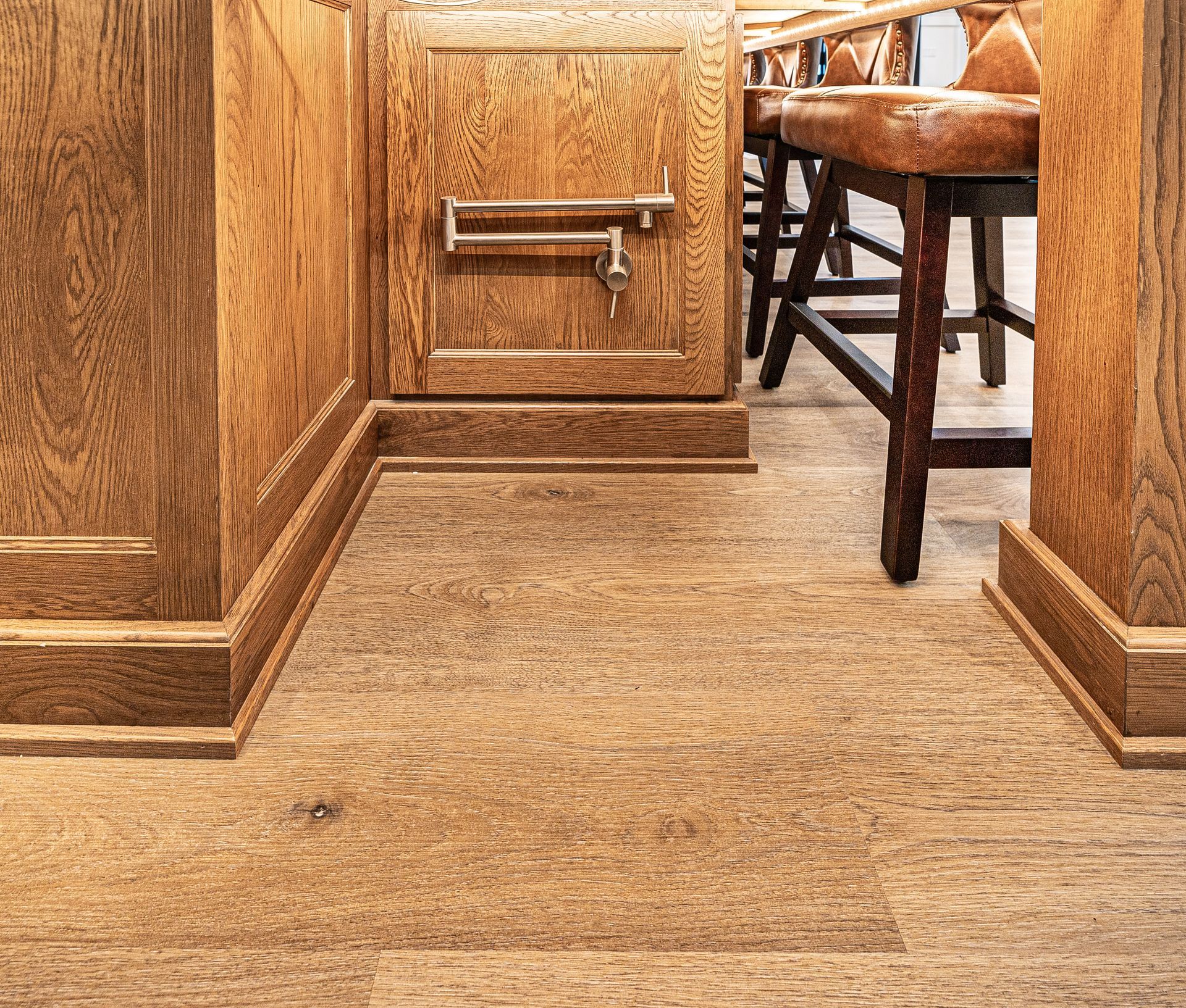 A wooden floor in a room with a desk and chairs.