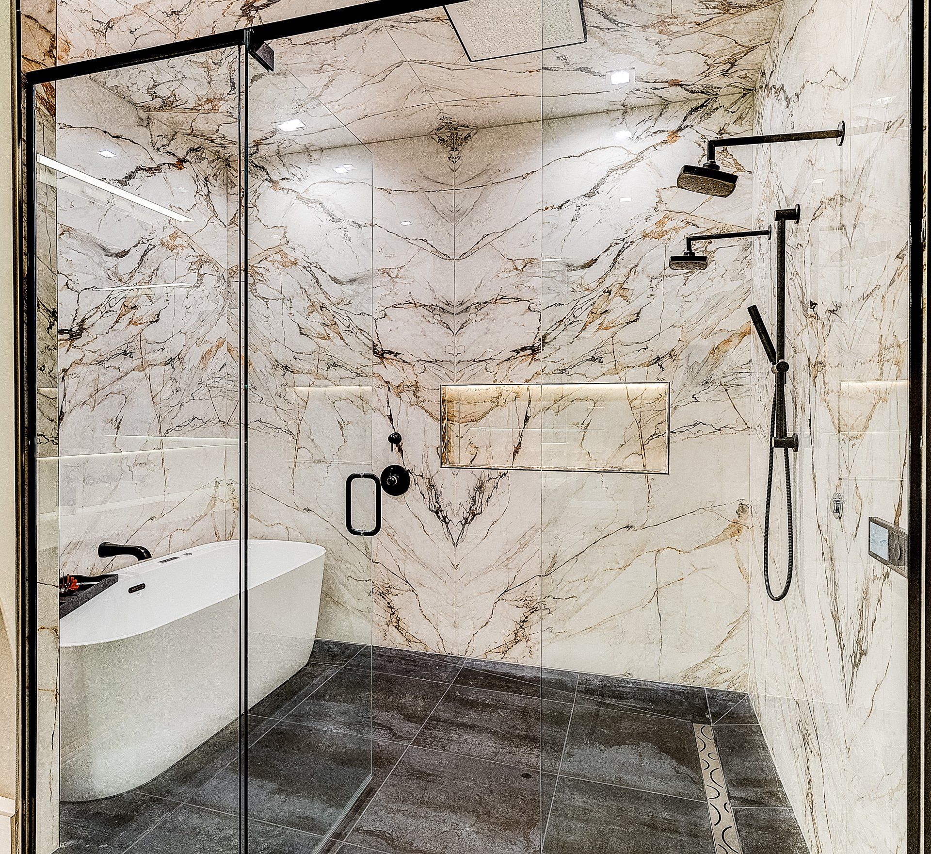 A bathroom with a bathtub , shower , and marble walls.