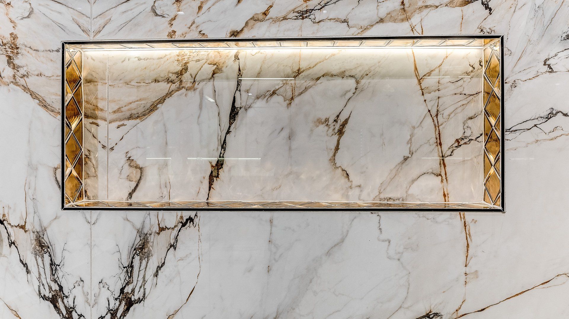 A marble wall with a drain in the middle of it.