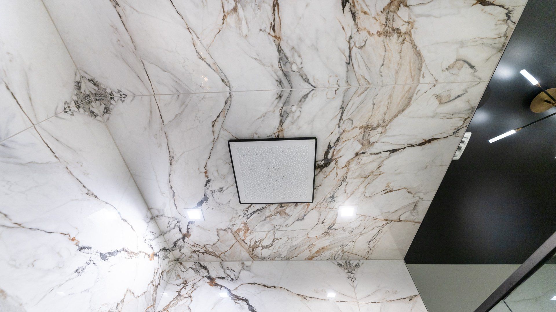 A bathroom with a marble ceiling and a ceiling fan.