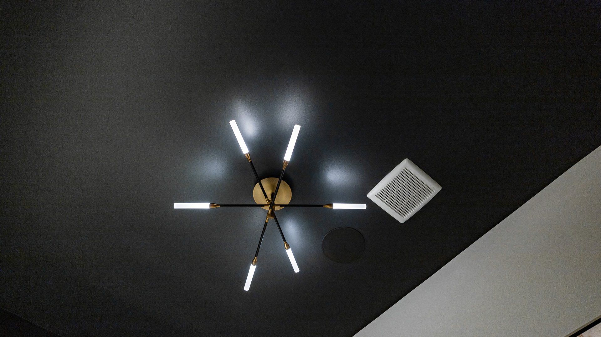 A light fixture is hanging from the ceiling in a dark room.