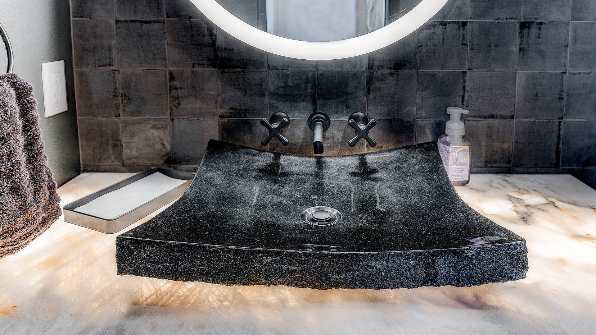 A bathroom with a black sink and a mirror