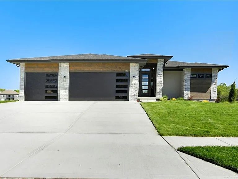 A large house with a concrete driveway and a large garage.