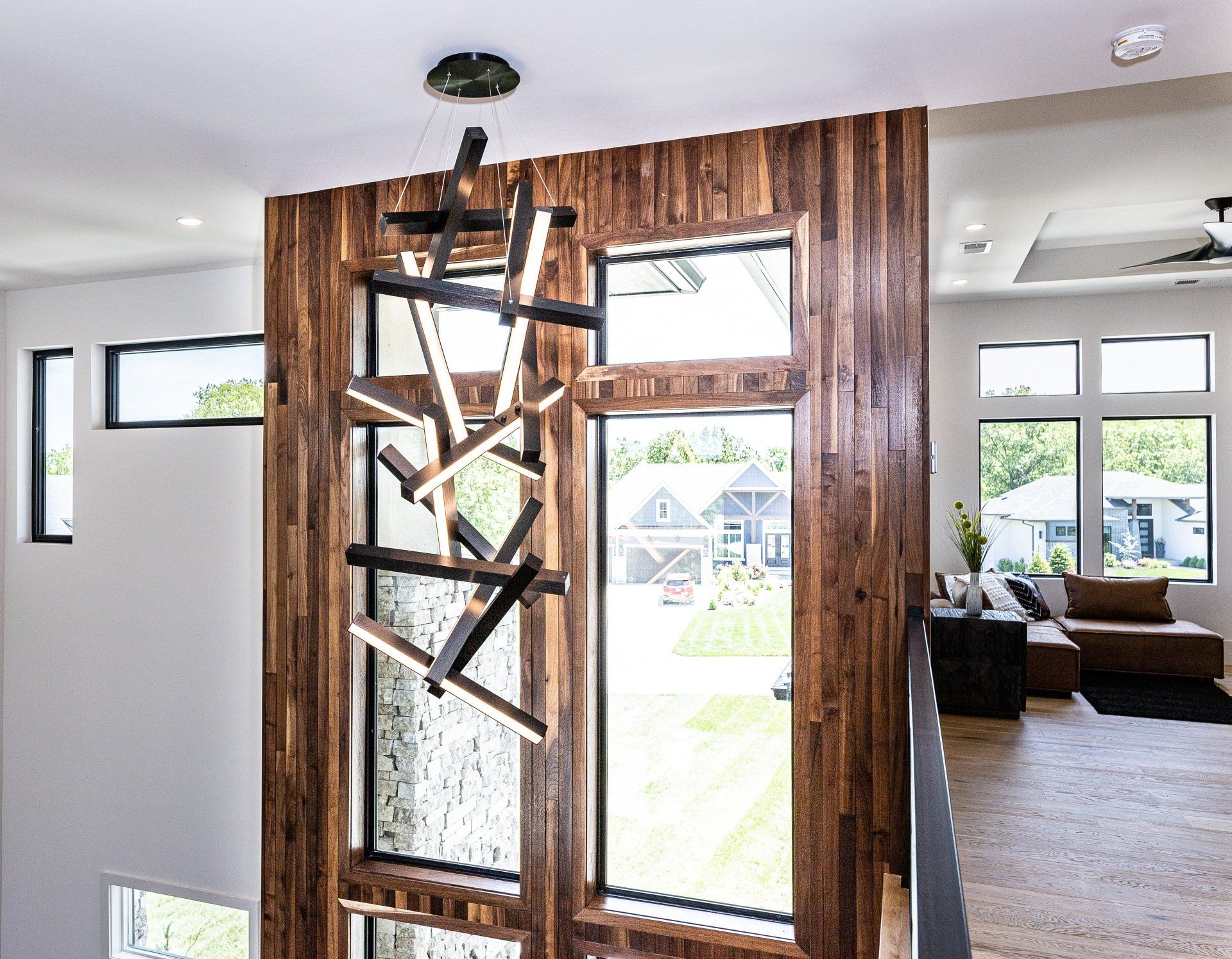 A living room with a wooden door and a chandelier hanging from the ceiling