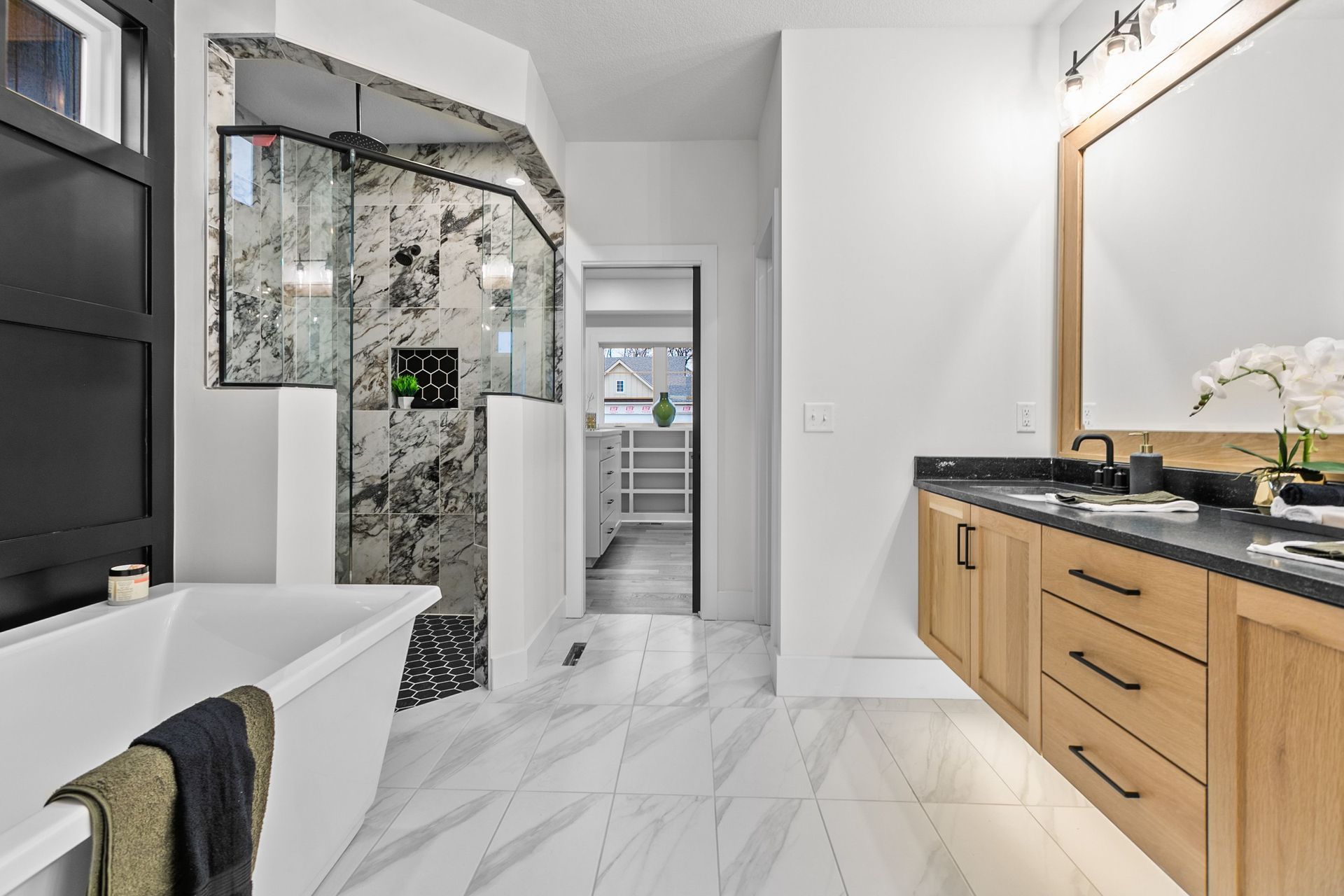 A bathroom with a bathtub , sink , mirror and walk in shower.