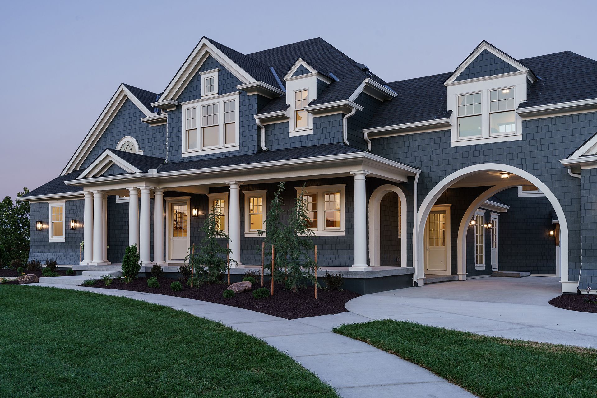 A large blue house with a large porch and arches