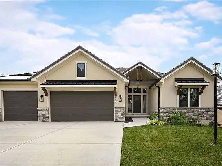 A large house with two garage doors and a large driveway.