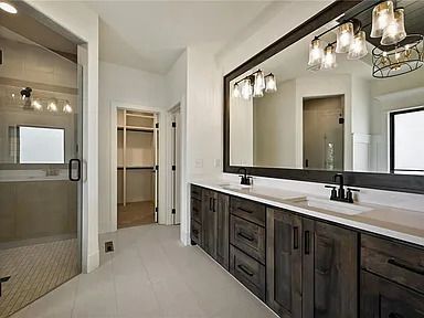 A bathroom with two sinks and a large mirror.