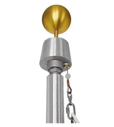 Close-up of a silver flagpole top with a gold ball finial, pulley, and attached rope.