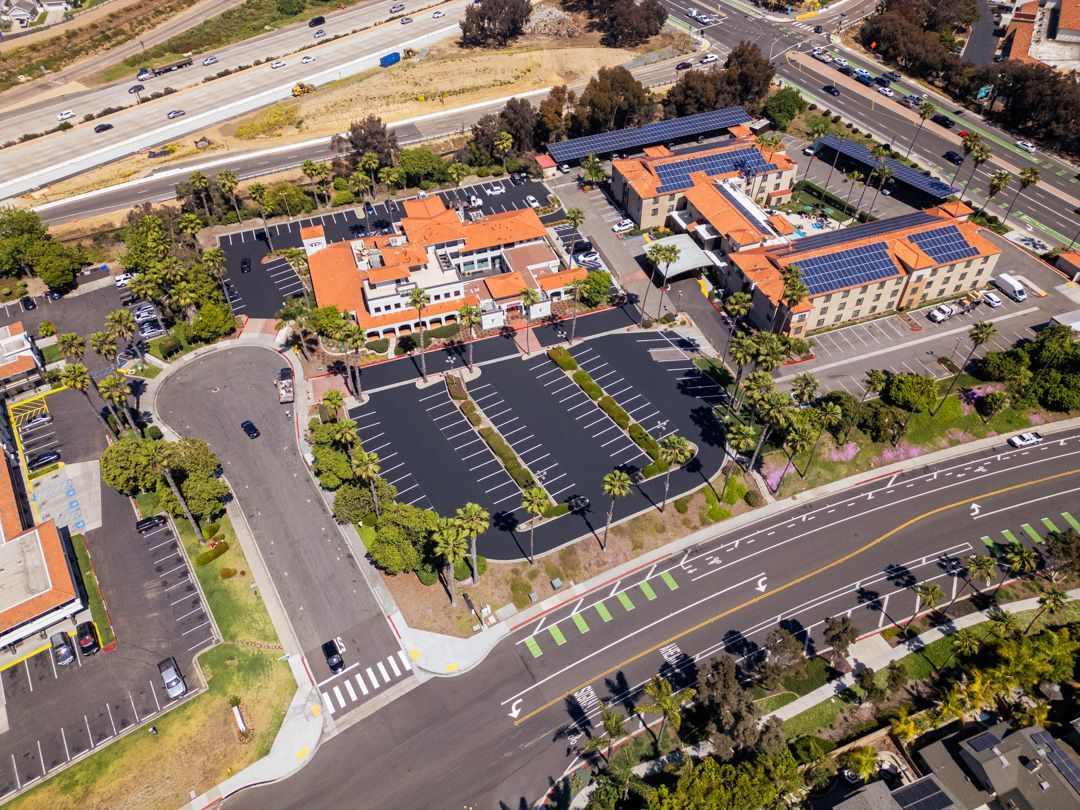 An aerial view of a large building with solar panels on the roof.