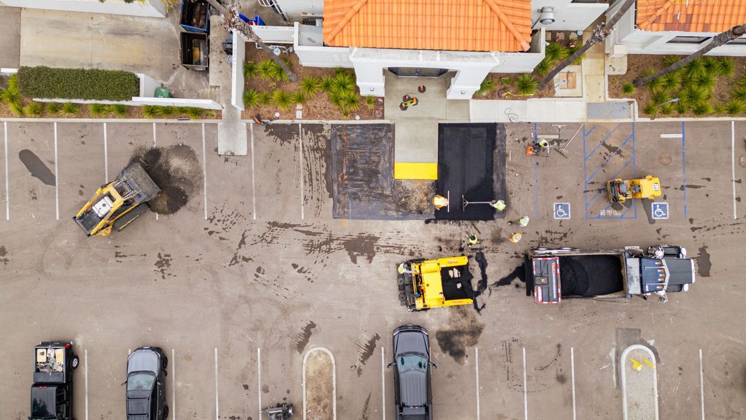 An aerial view of a parking lot being paved.