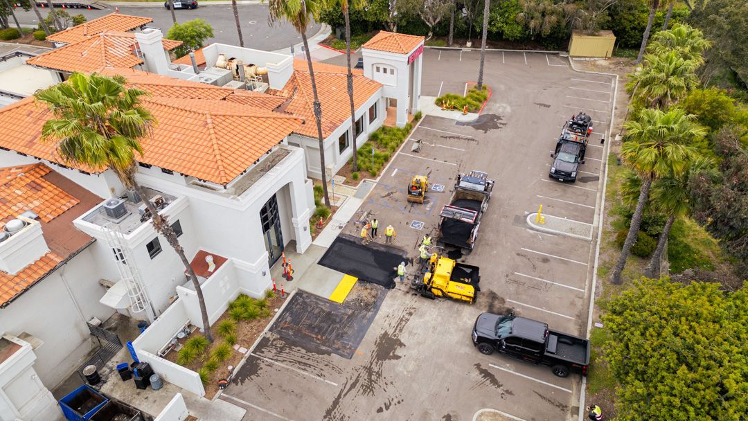 An aerial view of a parking lot with trucks parked in front of a building.