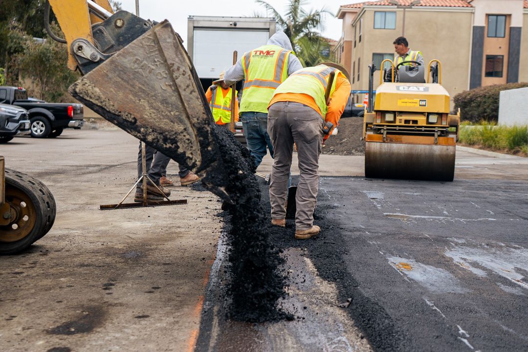A group of construction workers are working on a road.