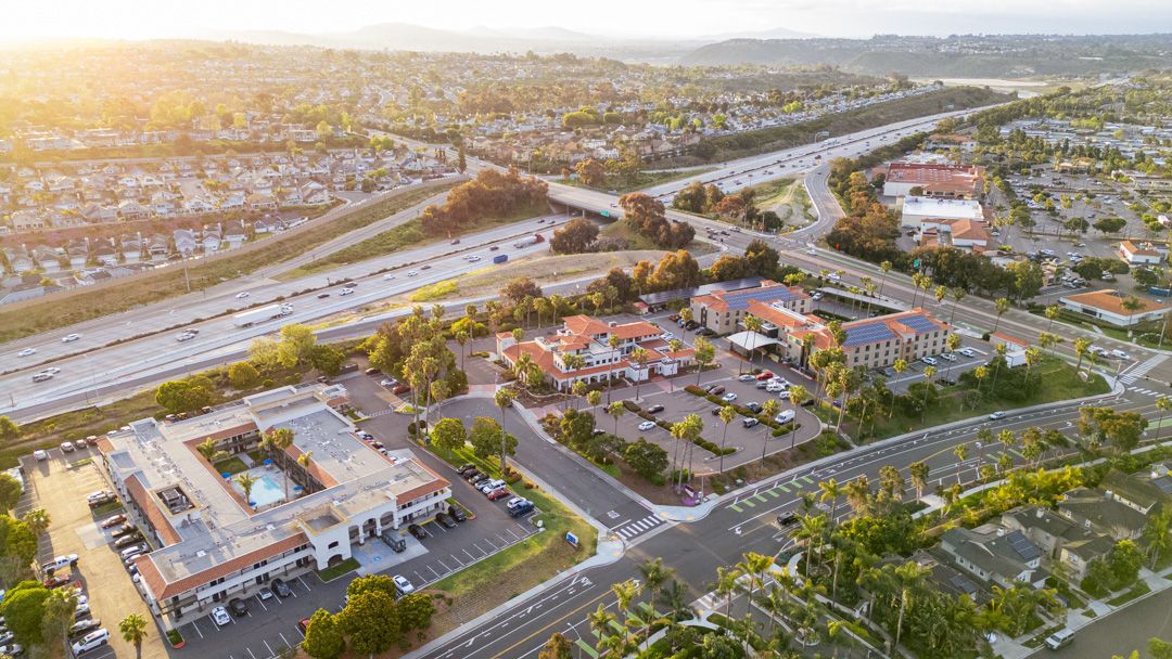 An aerial view of a residential area with a highway and buildings.