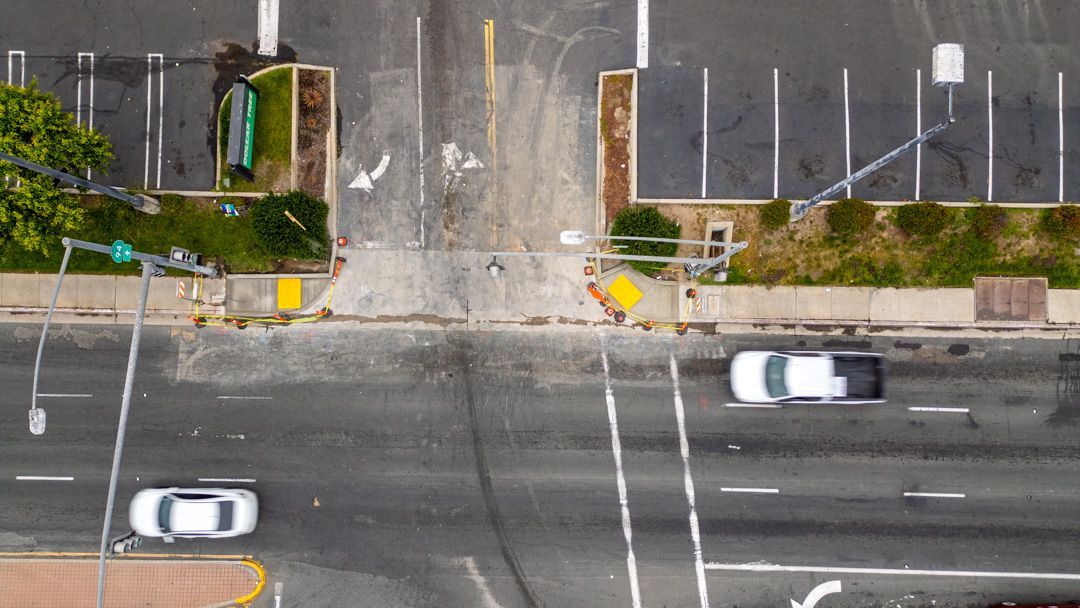 An aerial view of a city street with cars driving down it.