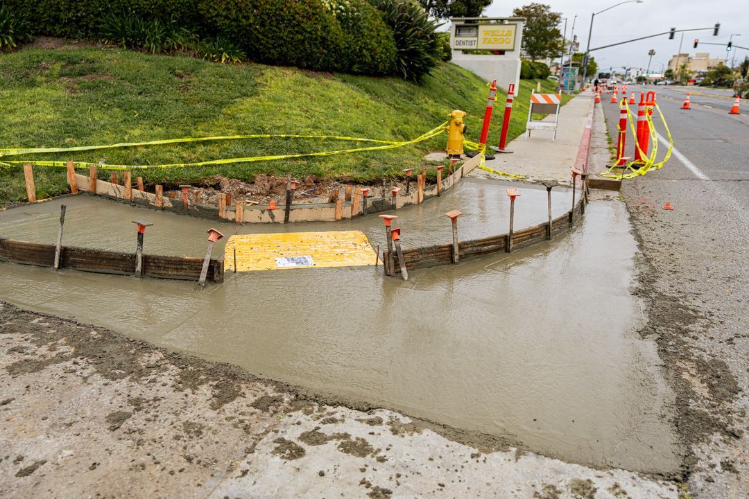 A concrete curb is being built on the side of a road.