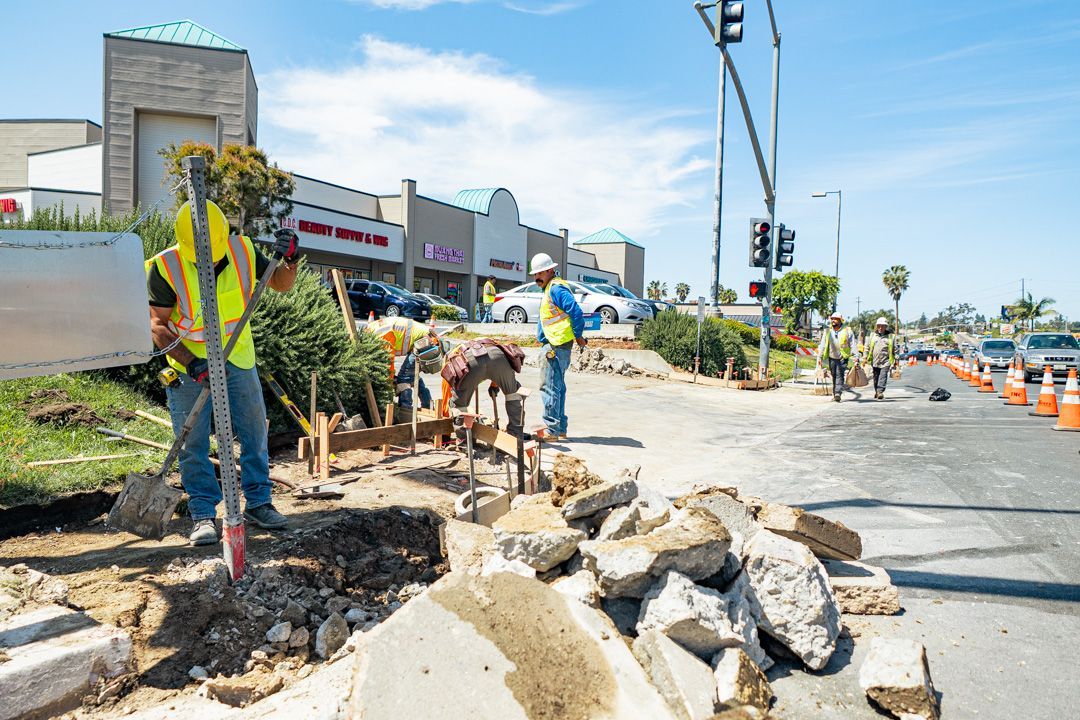 A group of construction workers are working on a road.