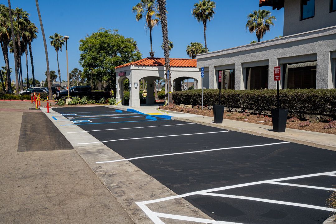 A parking lot with a handicapped parking space in front of a building.