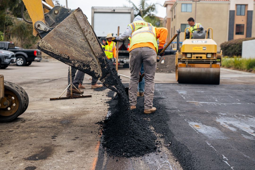 A group of construction workers are working on a road.