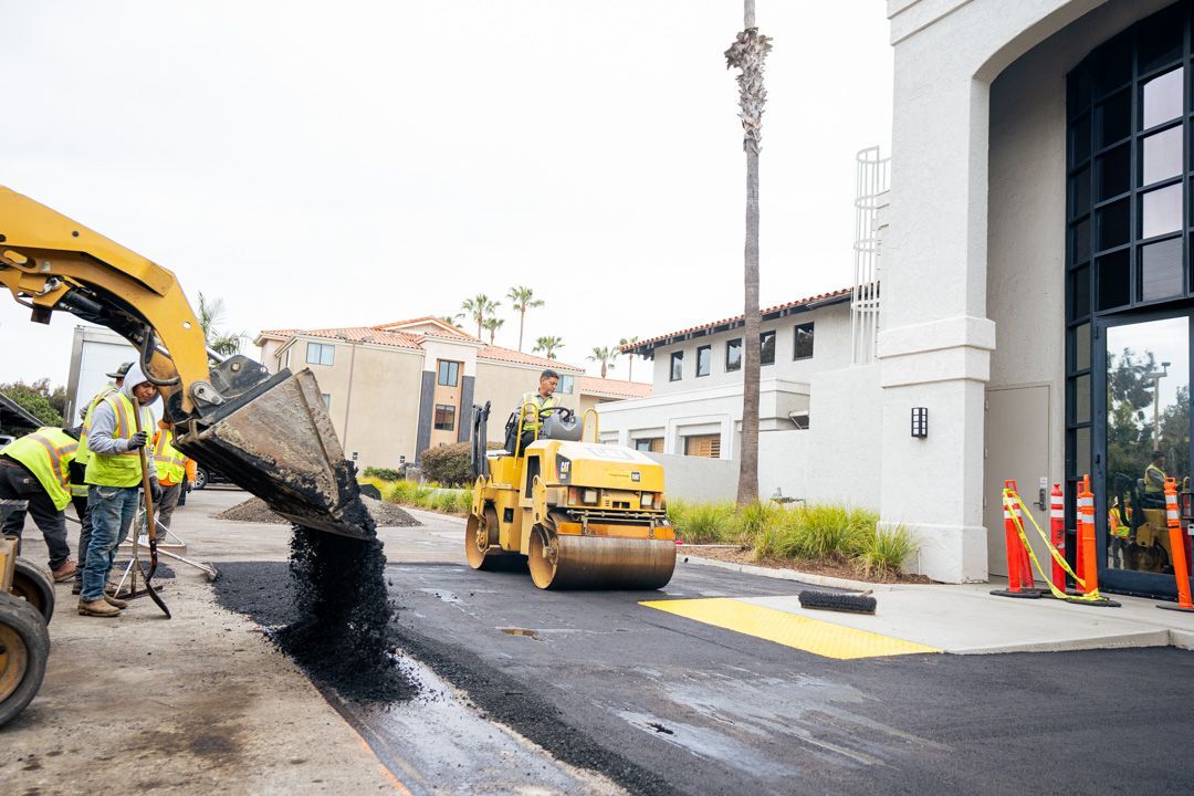 A group of construction workers are working on a road.