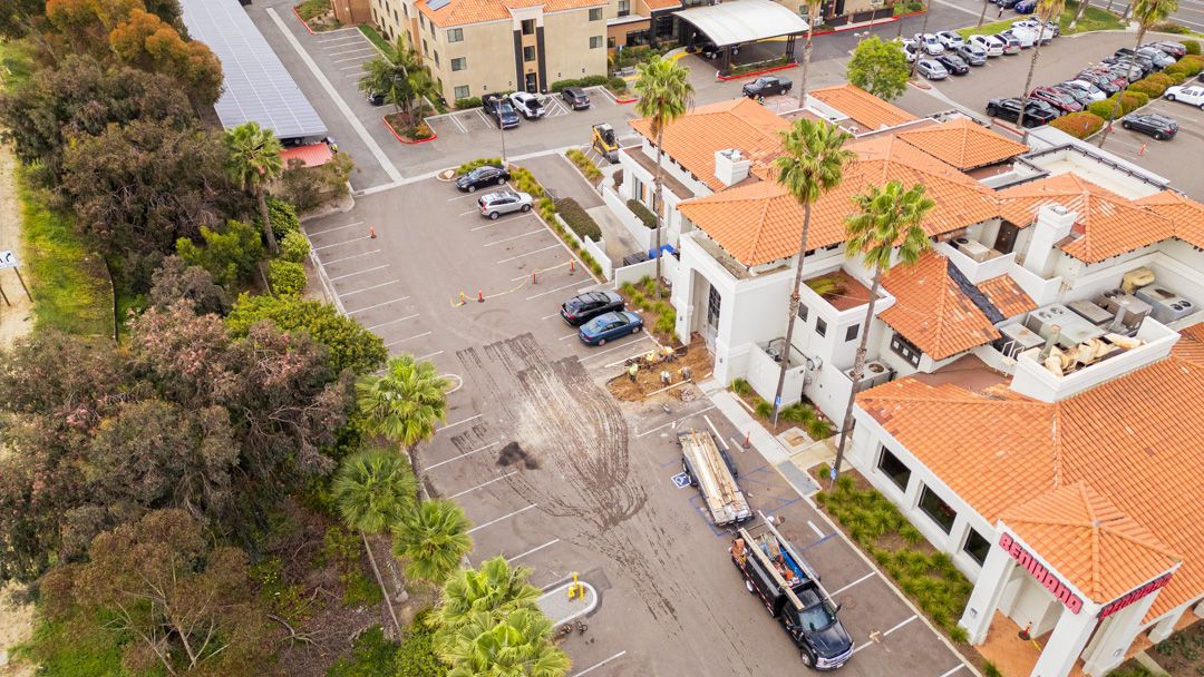 An aerial view of a large building with a lot of cars parked in front of it.