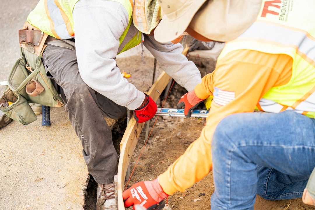 A group of construction workers are working on a road.