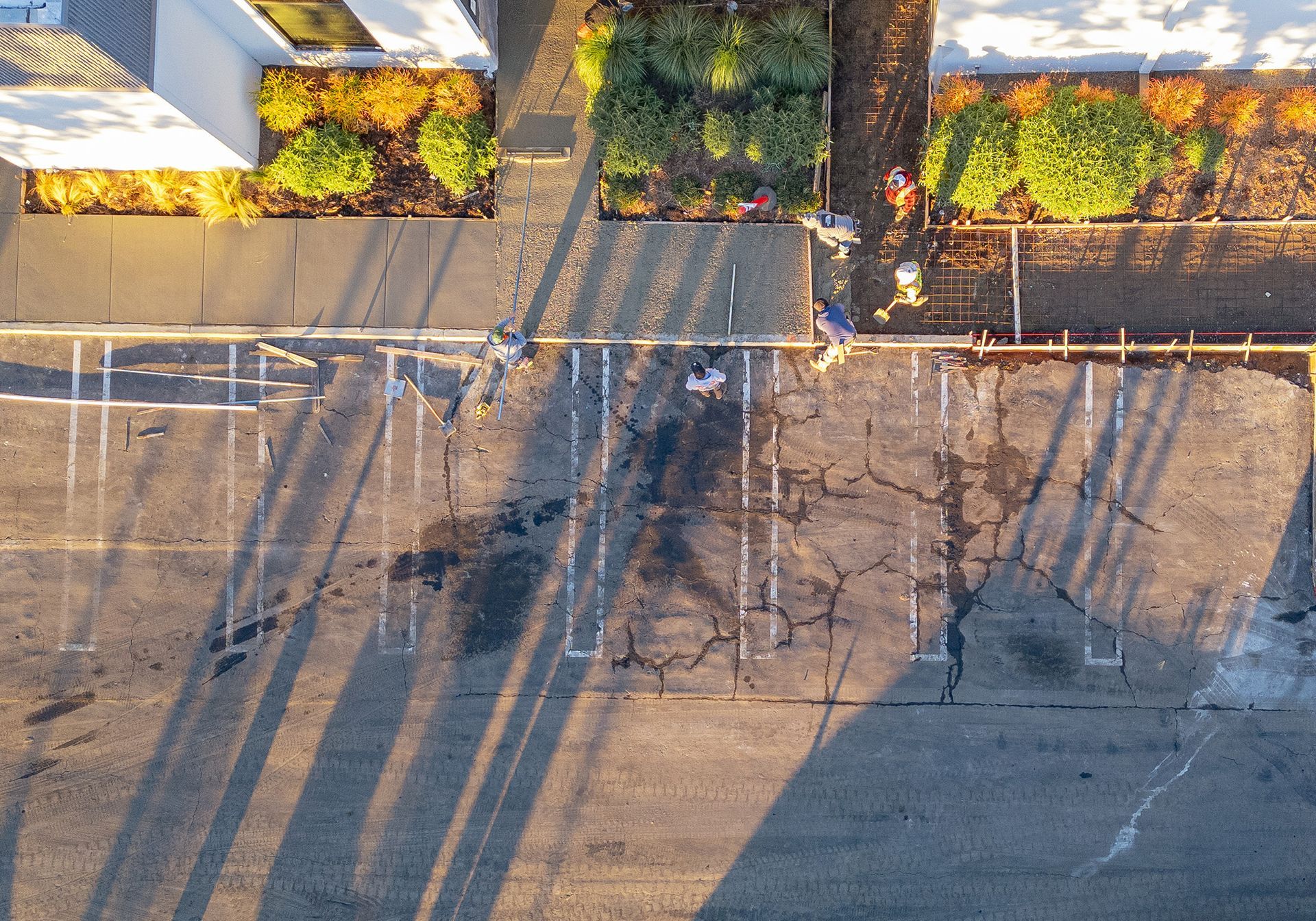 An aerial view of a parking lot with trees in the background