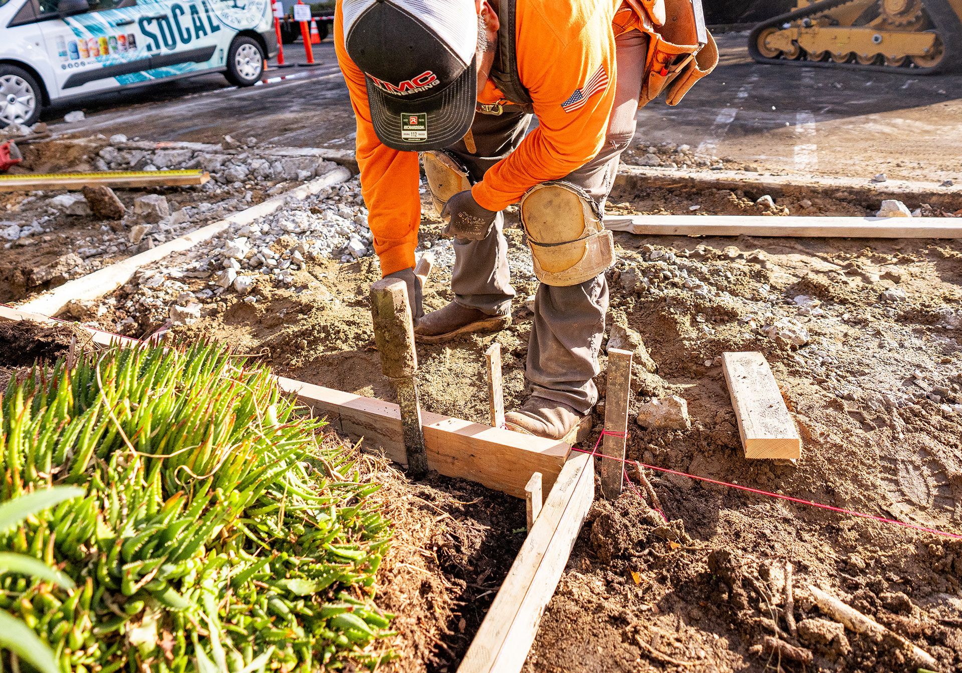 A construction worker is working on a concrete driveway.