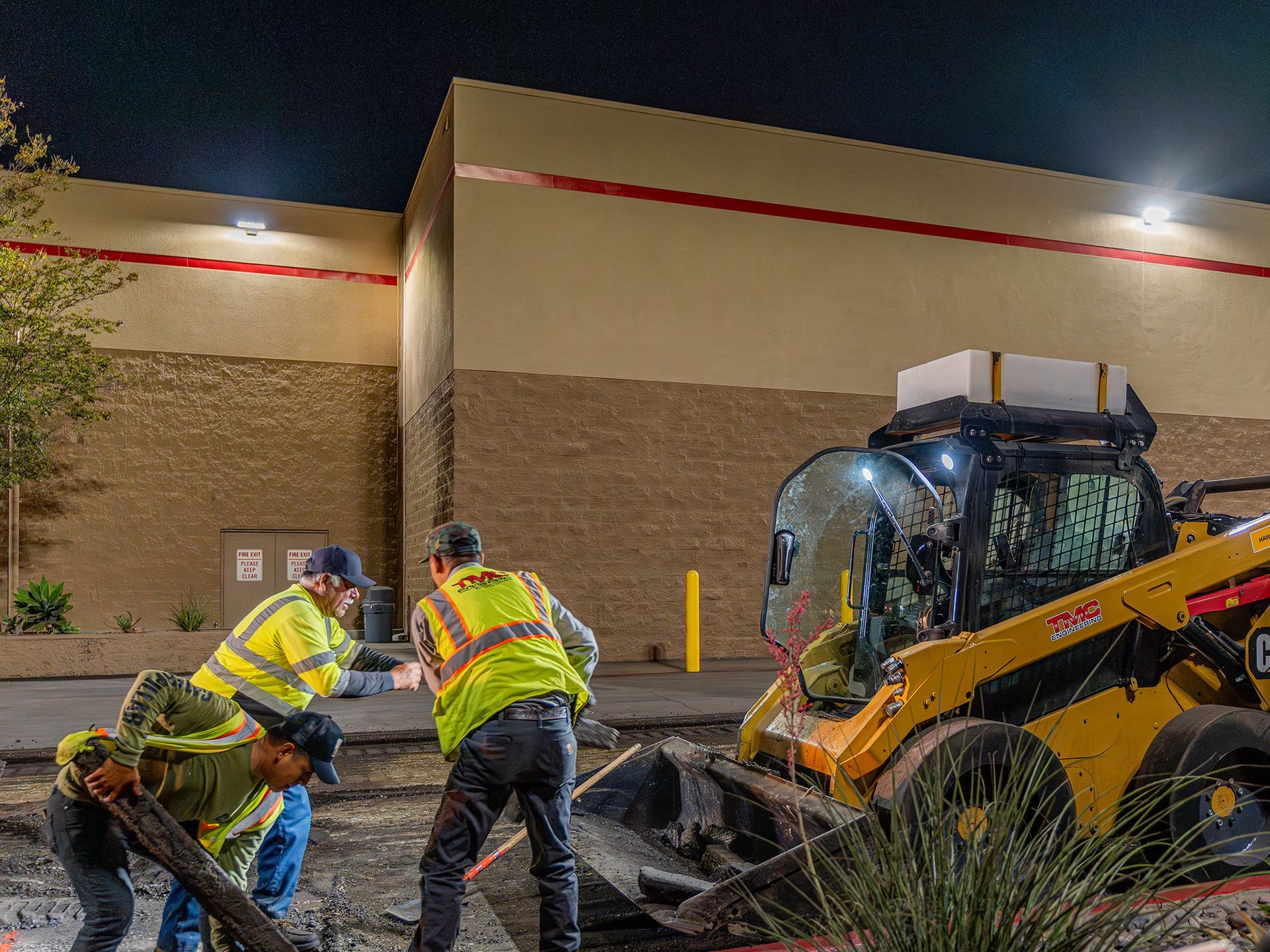 A group of construction workers are working on a construction site at night.