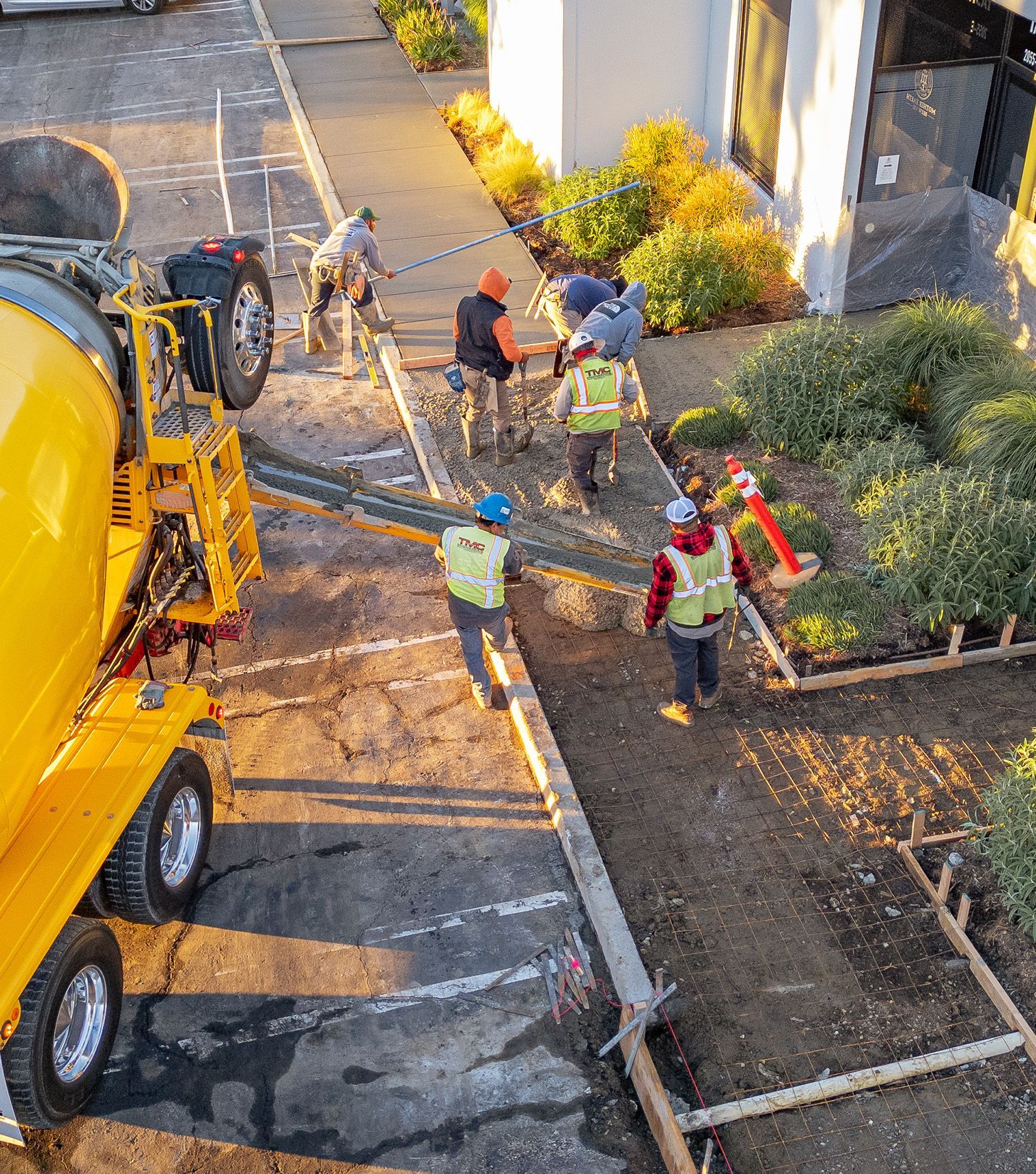 A group of construction workers are working on a concrete driveway