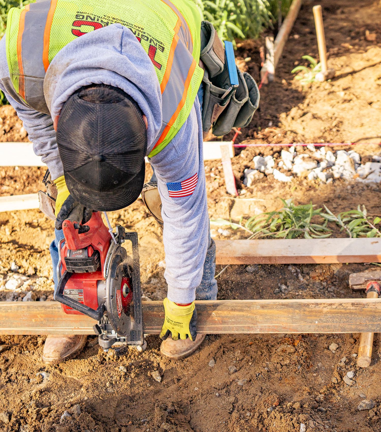 A man is using a circular saw to cut a piece of wood.