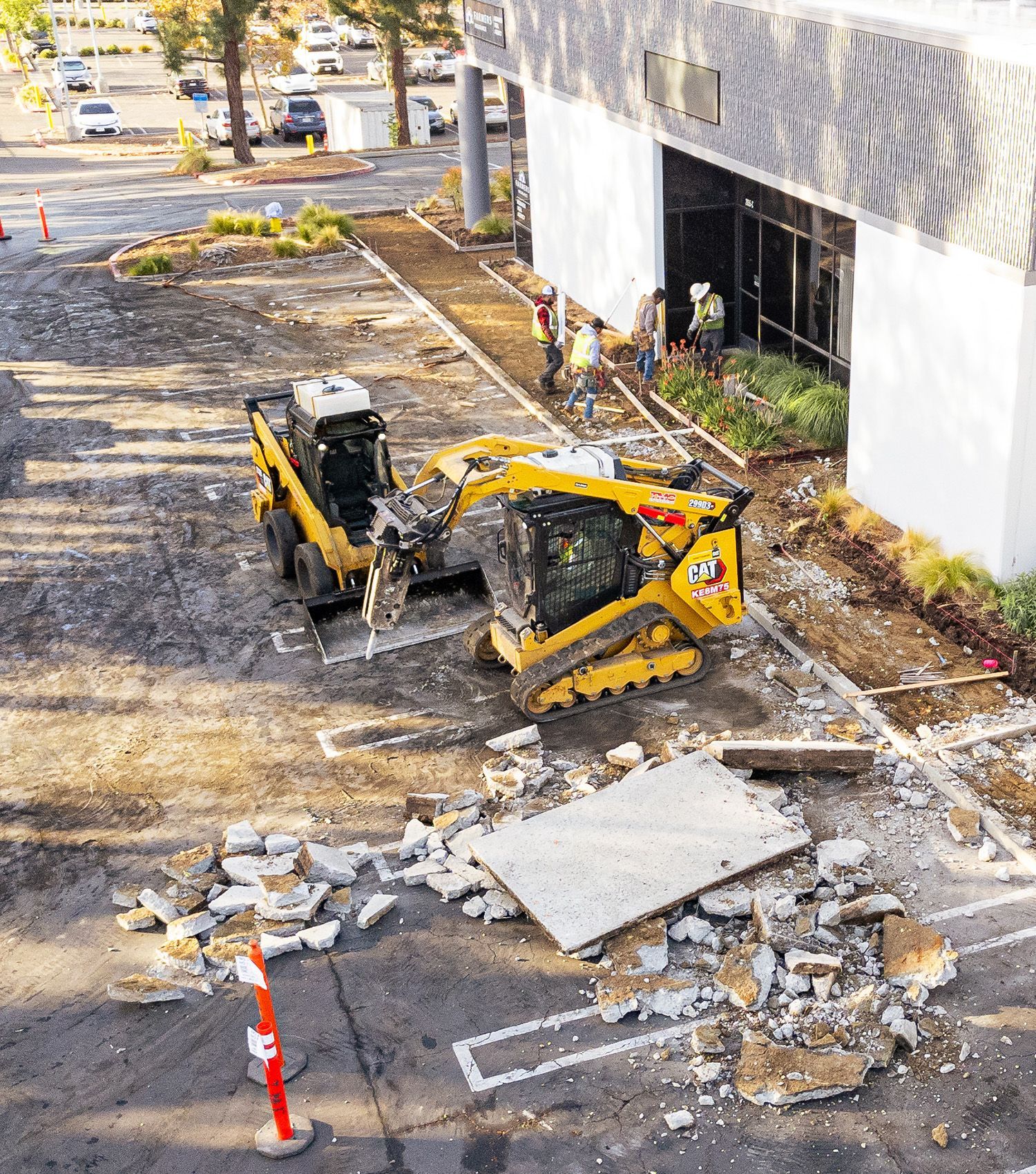 A bulldozer is sitting in a parking lot next to a building.