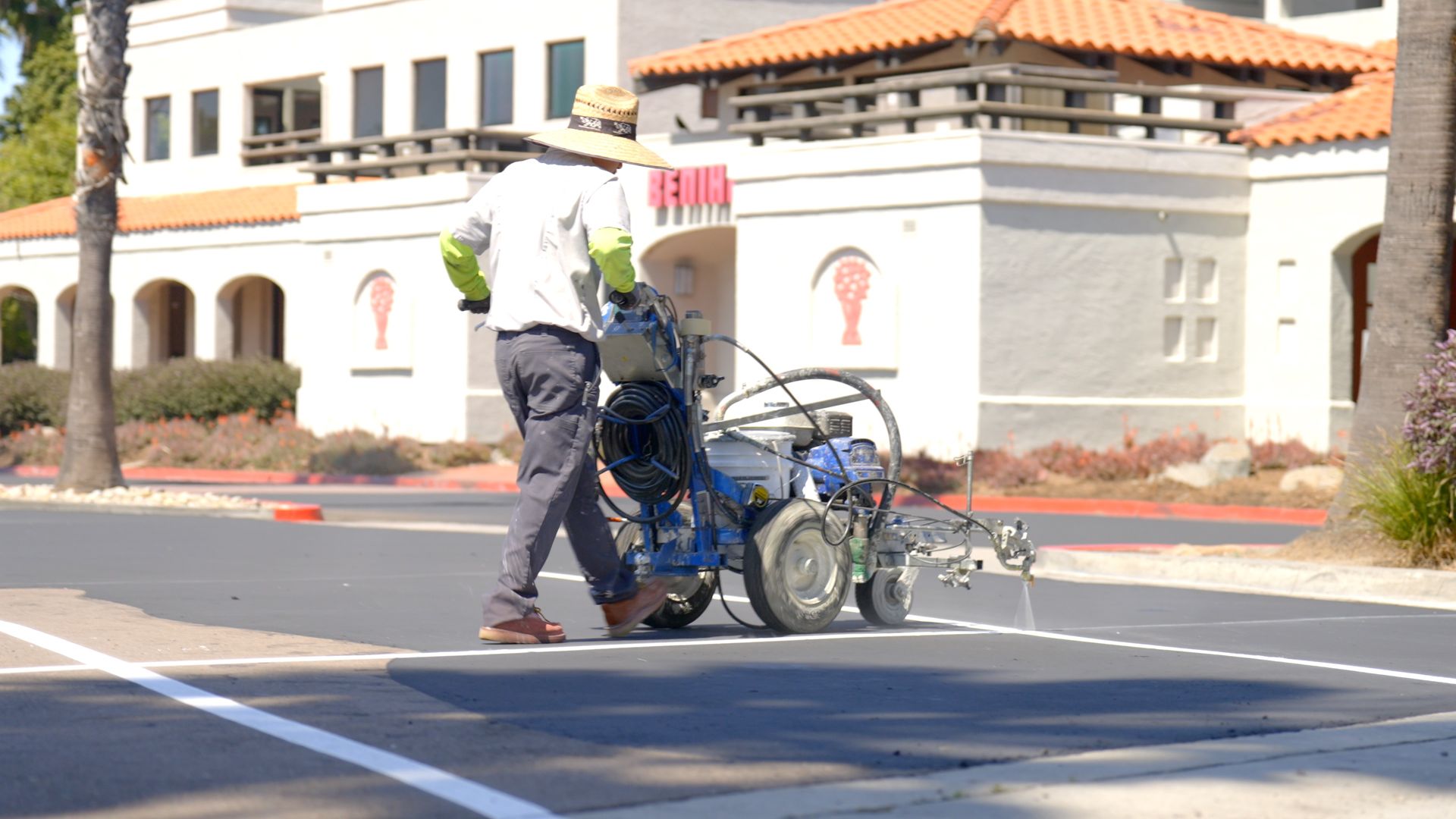A man is painting a white line on the road.