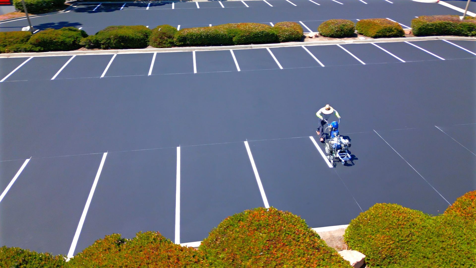 A person in a wheelchair is riding a bike in a parking lot.