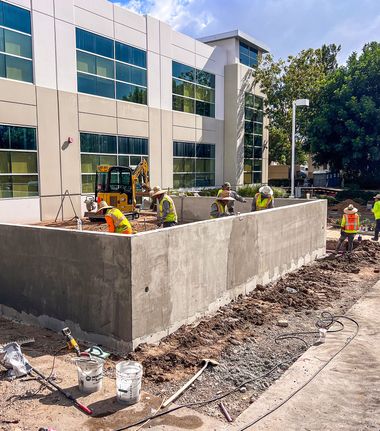 A group of construction workers are working on a concrete driveway