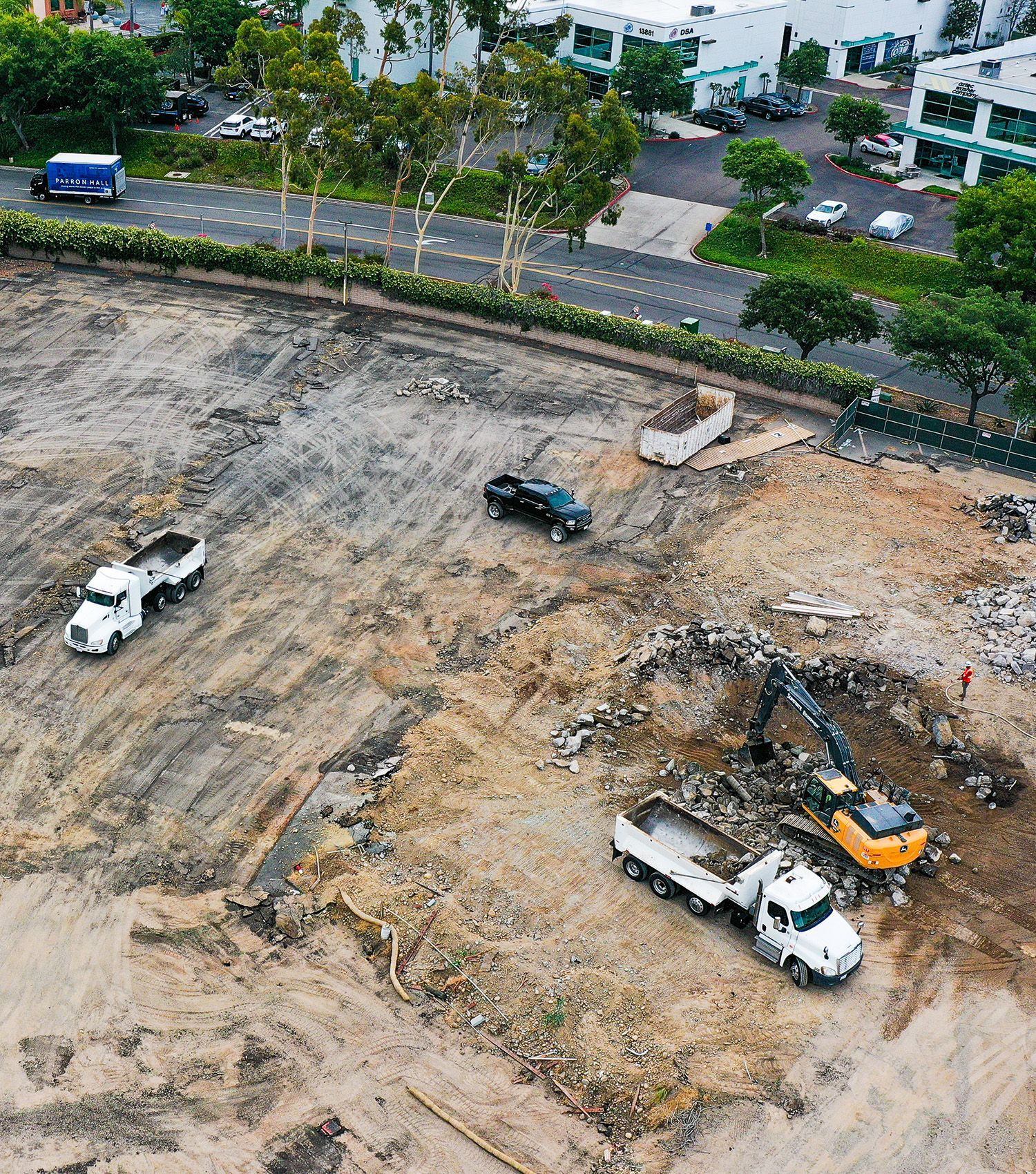 An aerial view of a construction site with trucks and a bulldozer.