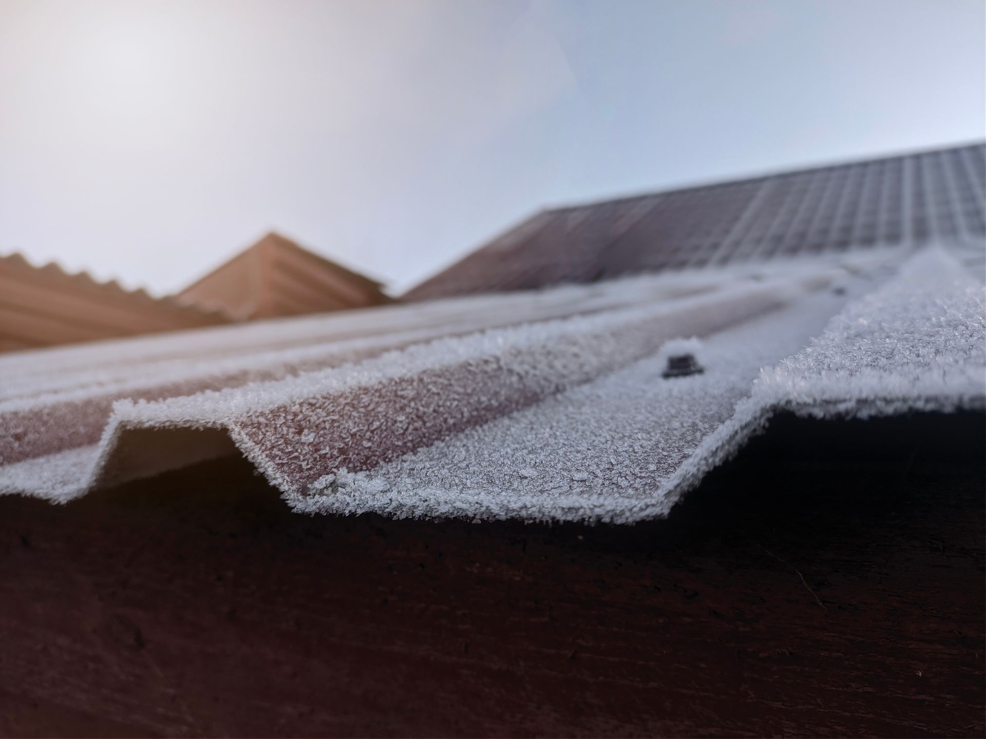 Frosted metal roof with a light blue sky in the background.