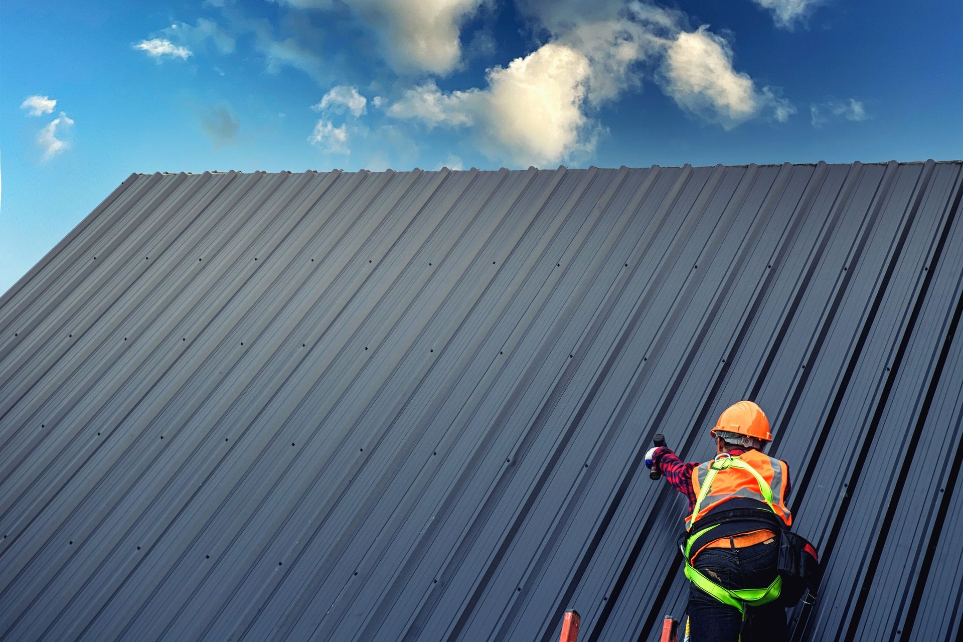 A man is standing on top of a metal roof.