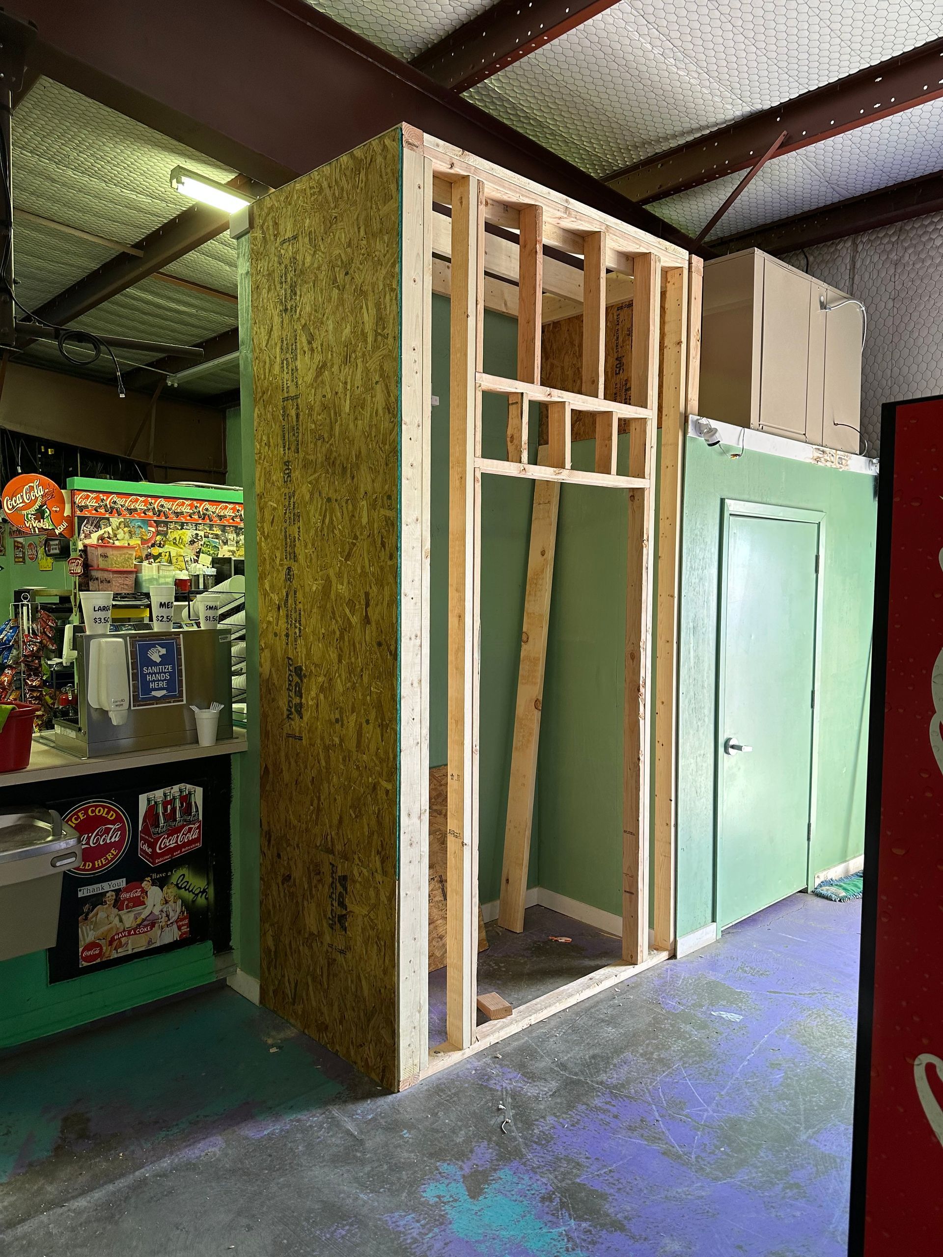 a building under construction with a coca cola machine in the background .