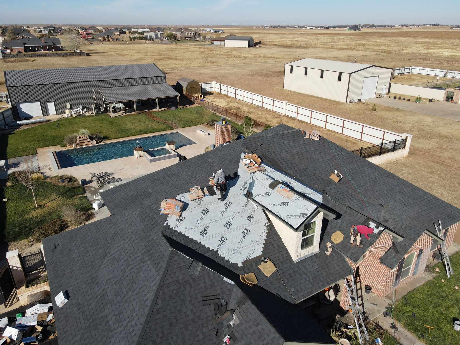 an aerial view of a house with a roof being installed .