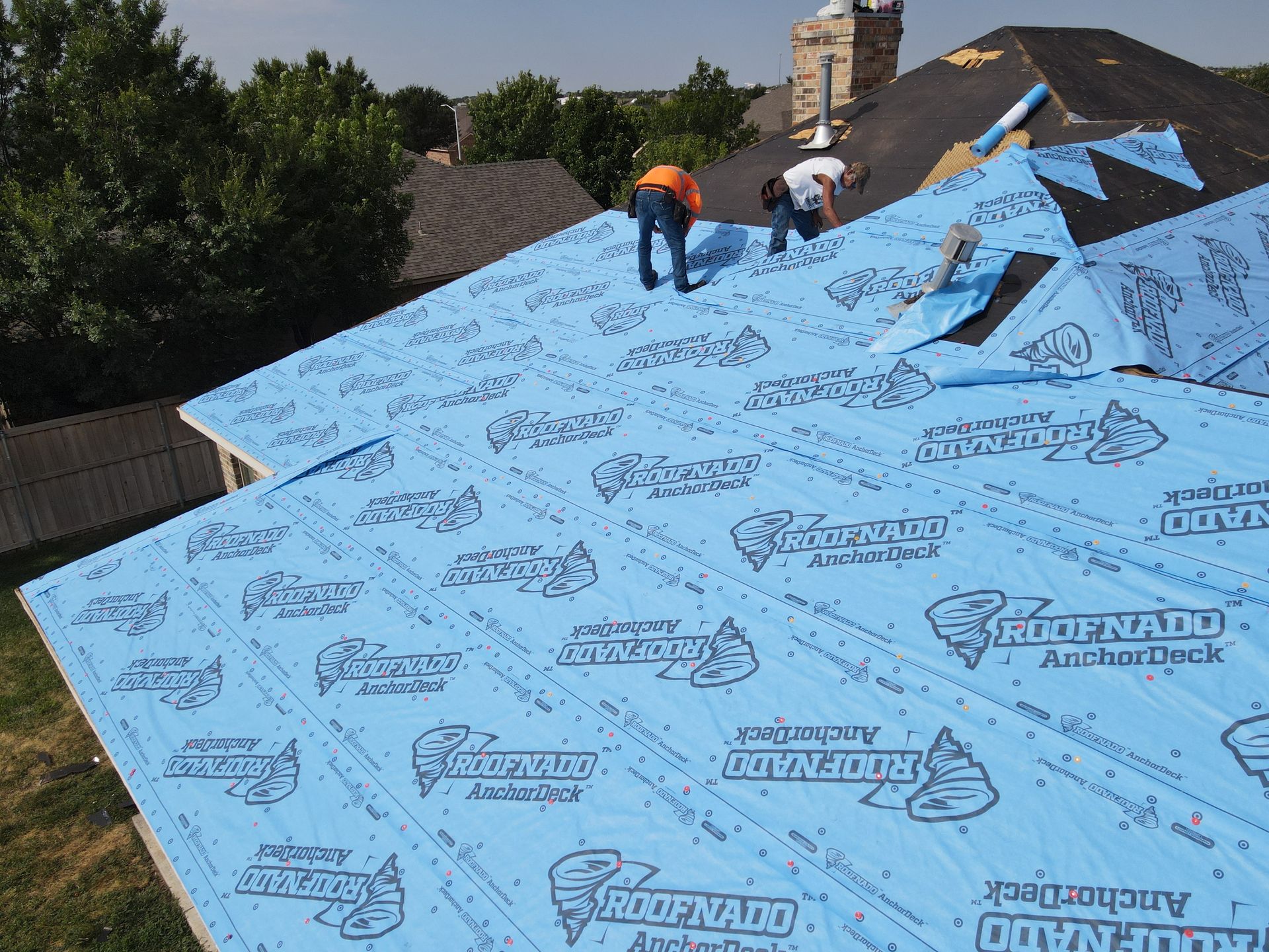two men are working on the roof of a house