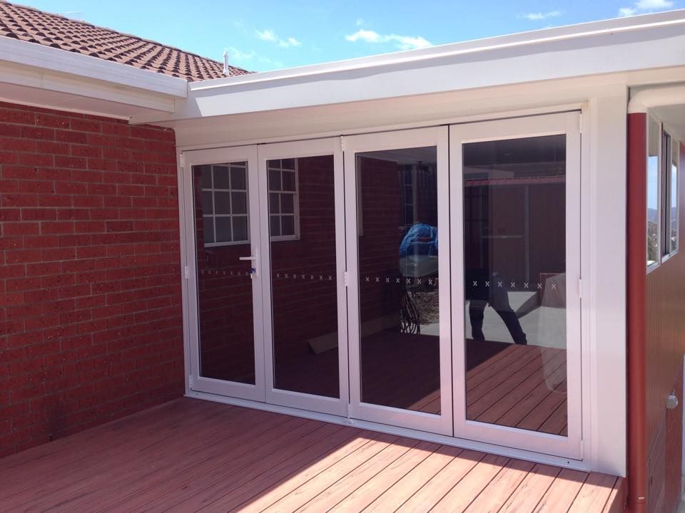 A brick house with a deck and sliding glass doors