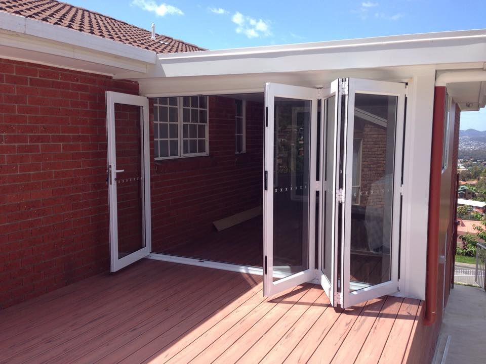 A brick house with a deck and sliding glass doors