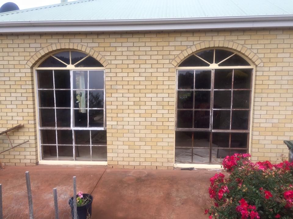 A brick building with arched windows and a potted plant in front of it