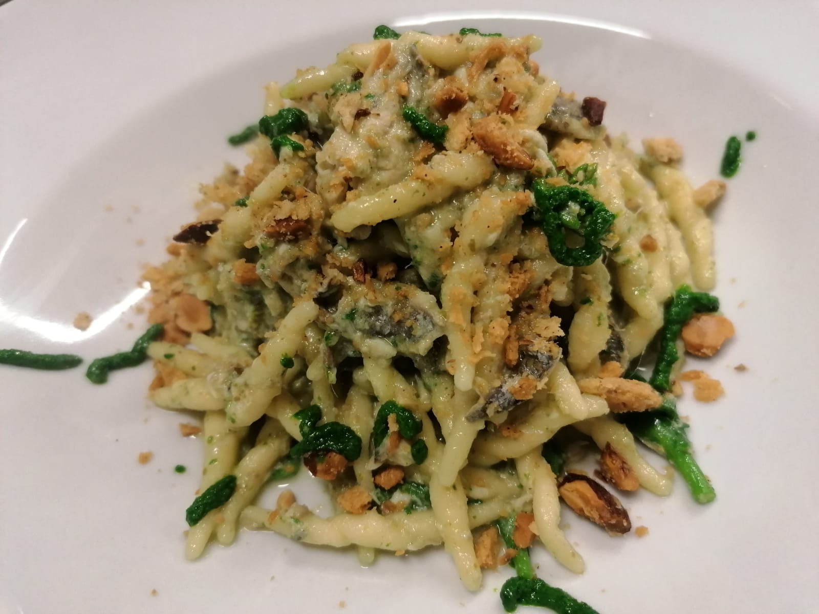 Un piatto bianco con sopra pasta e verdure