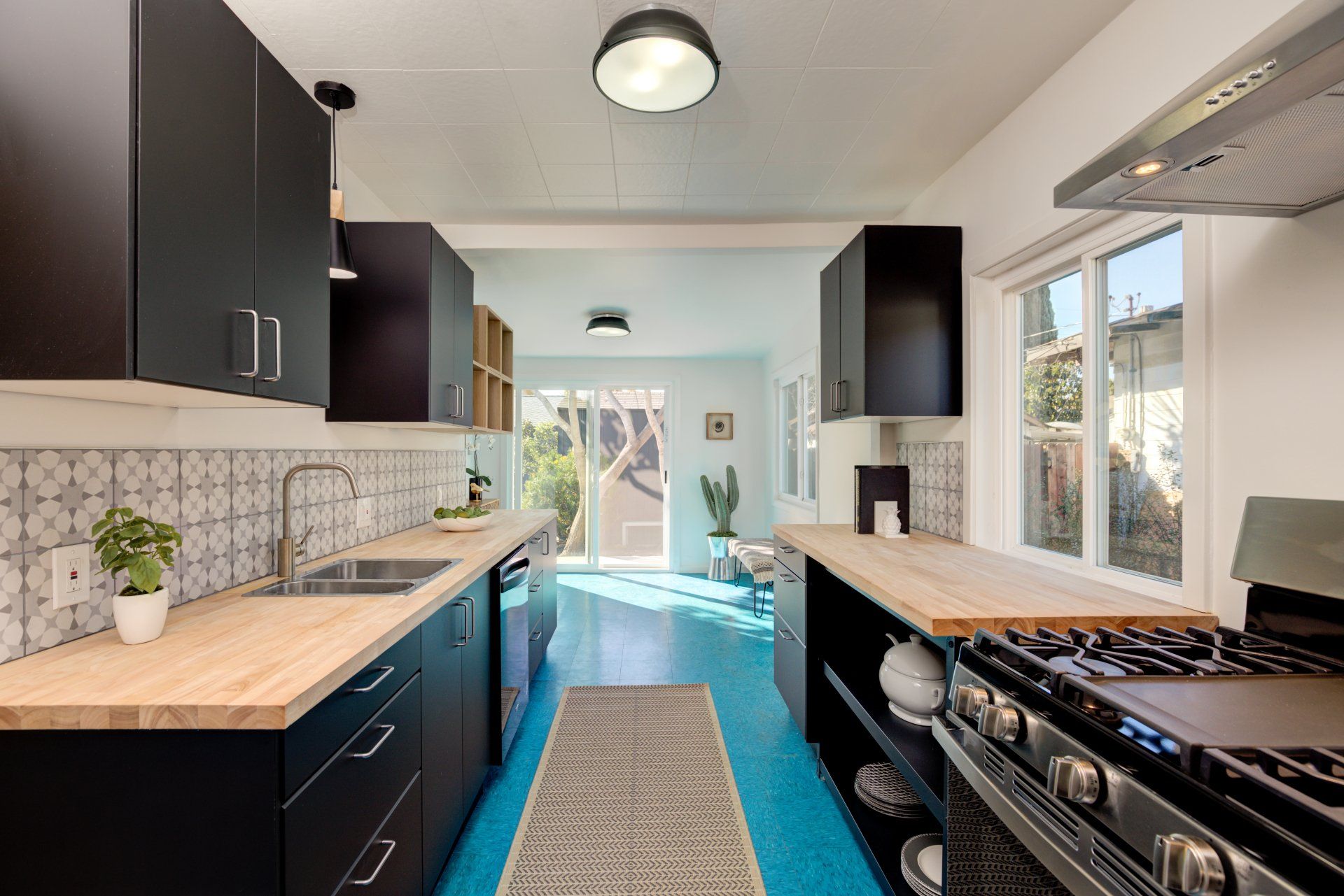 A kitchen with black cabinets and a blue floor