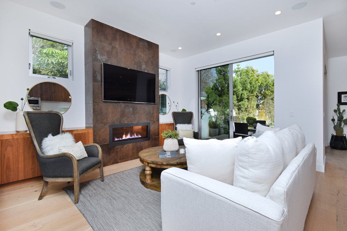 A living room with a fireplace , couch , chair and television.