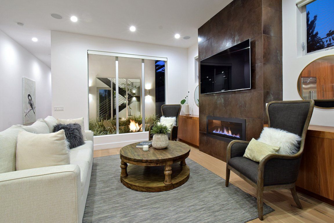 A living room with a couch , chair , coffee table and fireplace.